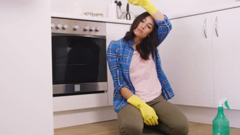 Mujer-Cansada-Sentada-En-El-Suelo-Durante-La-Limpieza