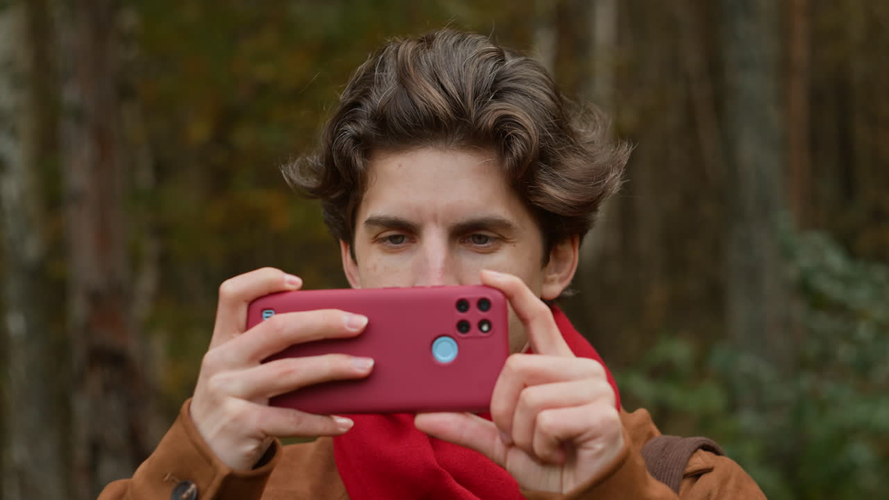 Man taking photos in the autumn woods
