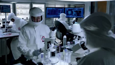 scientists in protective gear working in a laboratory