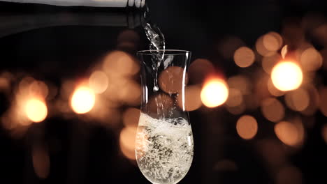 pouring champagne in flute with sparklers fireworks lights on black background