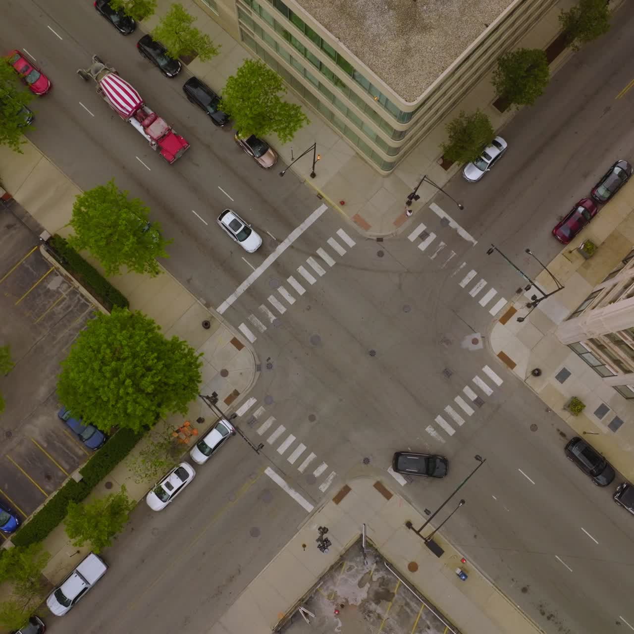 Crossroads and parking lots between the buildings. Drone descending over the road. Bird's eye view