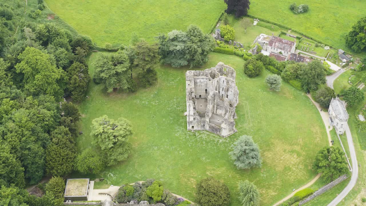 Old Wardour Castle ruins surrounded by bright green fields and forest, High angle aerial view