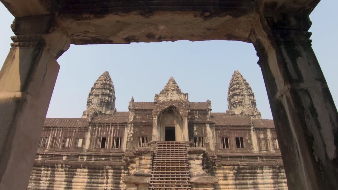 toma en movimiento lento a través de una antigua puerta de entrada hacia el templo de angkor wat en camboya