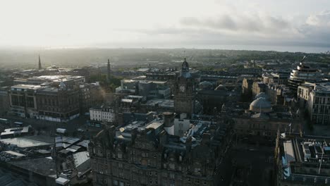 Wide-aerial-view-of-The-Balmoral-clock-tower-in-Scotland,-surrounded-by-historic-architecture