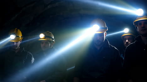 group of miners with headlamps in a dark underground setting