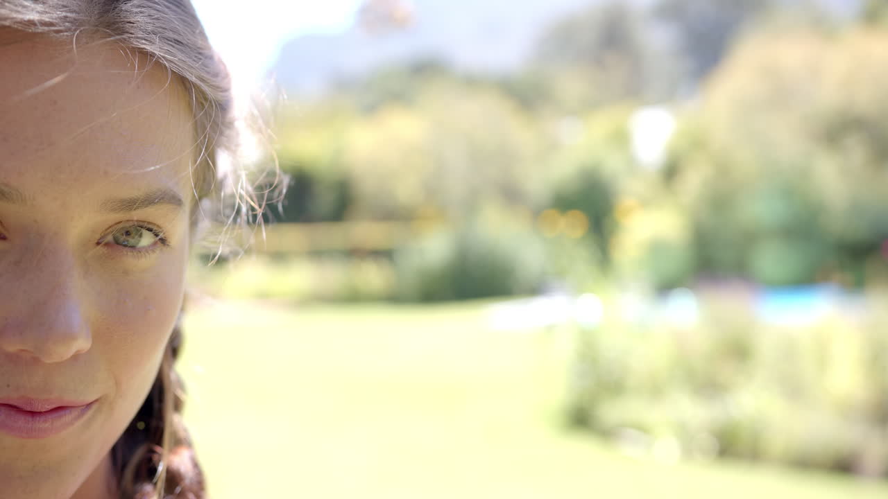 Smiling woman with braided hair enjoying sunny day outdoors in garden, copy space