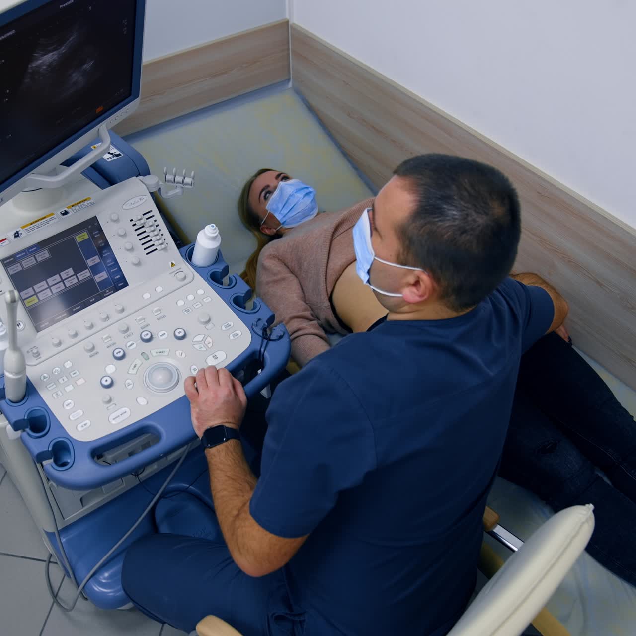 Female patient undergoing ultrasound check up of kidneys. Health examination in modern clinics. Top view