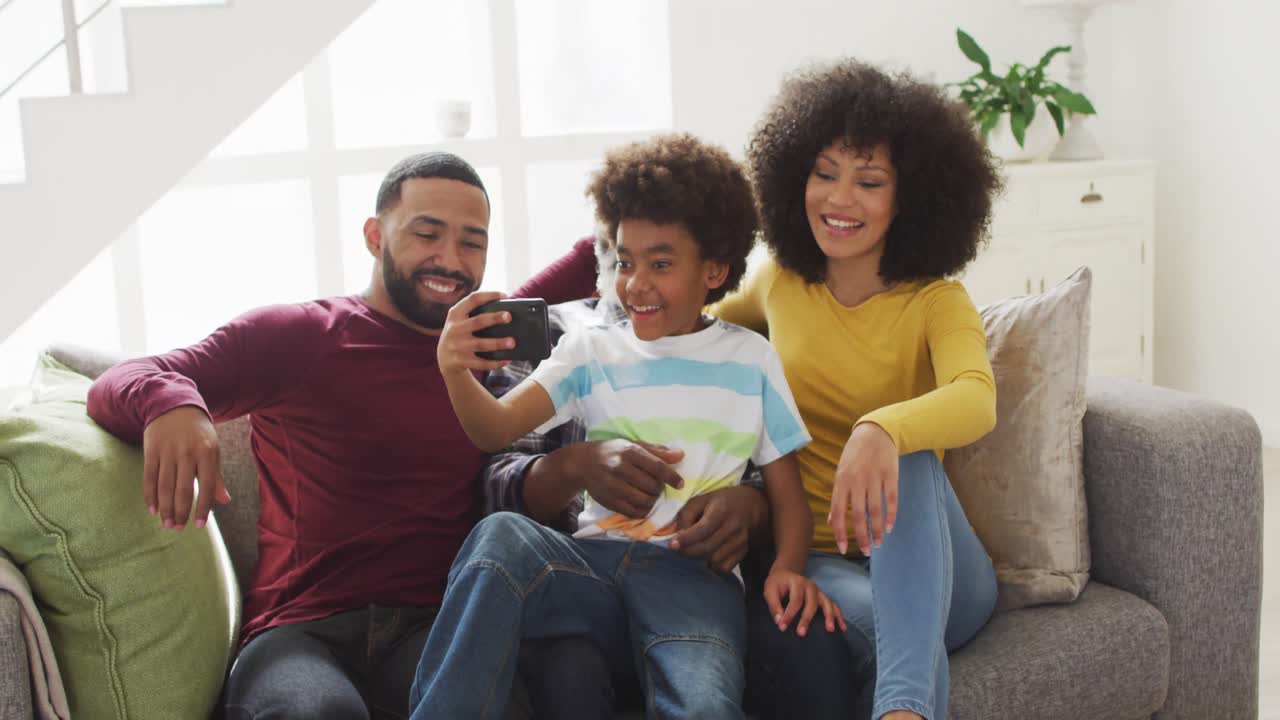 Multi-generation family taking a selfie on couch at home