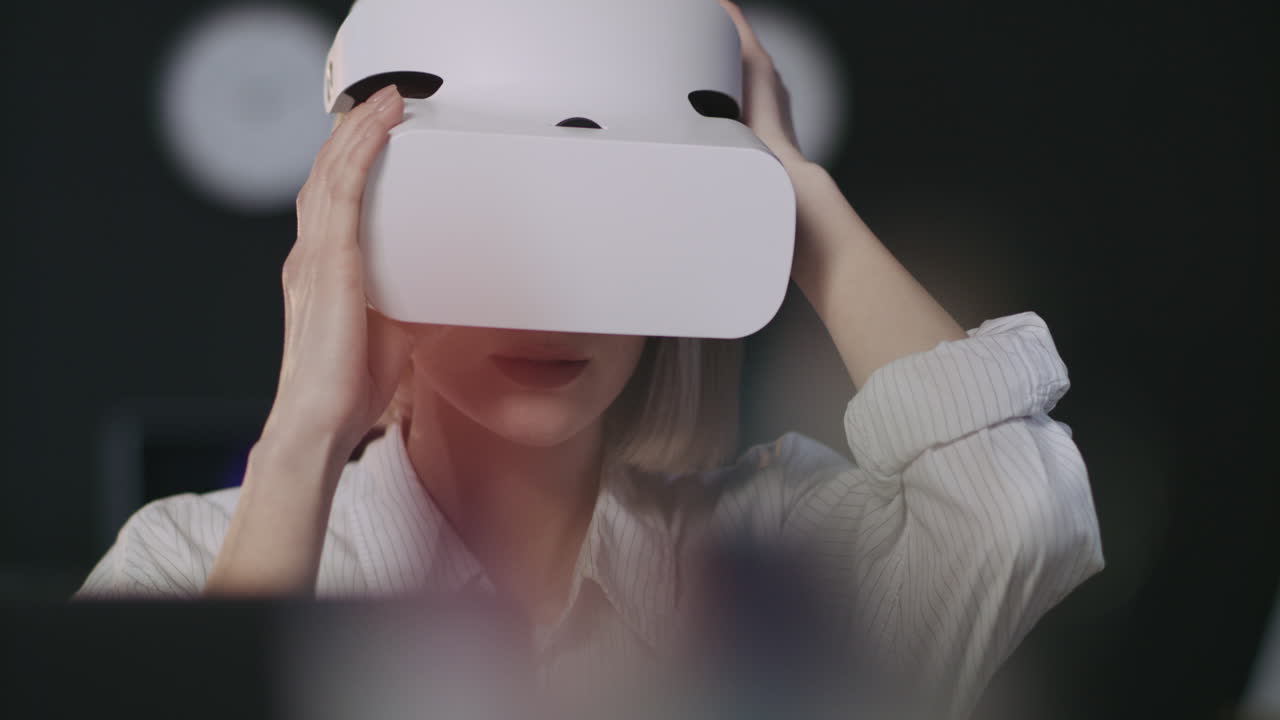 Young woman working with VR goggles in dark office