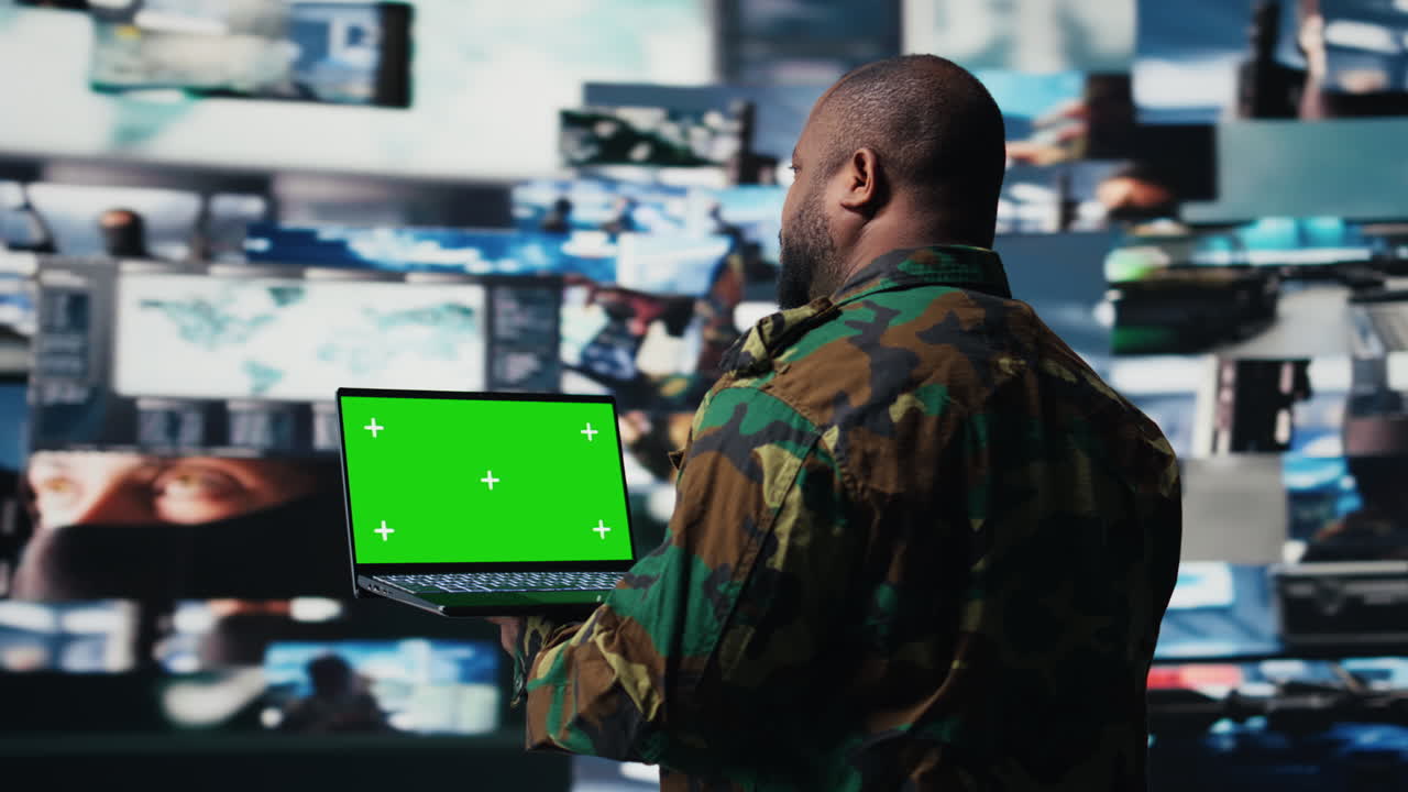 Black military personnel uses green screen on pc in command center