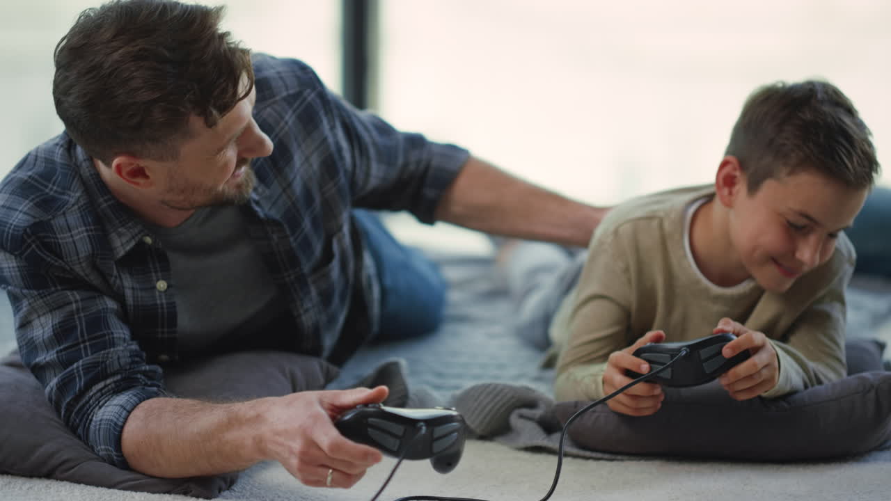 Father and son playing on console indoors. Parent and kid gaming on play station