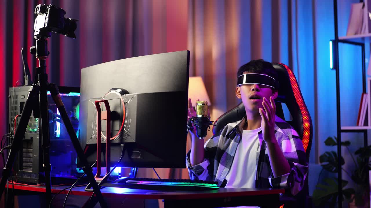asian boy streamer jugando juego, tocando y deslizando experiencia de realidad virtual en gafas futuristas. jugador tocando panel de aire. computadora personal en el escritorio iluminada por luz de tira de led rgb
