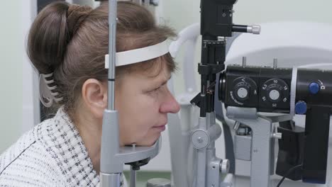 woman doctor is viewing through ophthalmoscope in eyes of patient in ophthalmologic clinic. professional inspection of vision