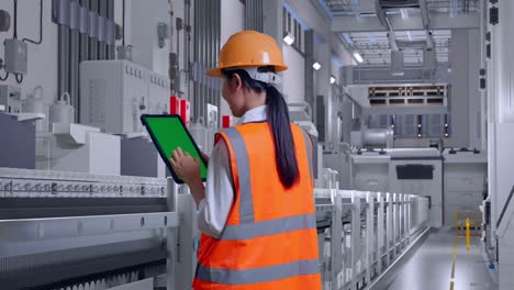 ingeniera inspeccionando maquinaria en una fábrica
