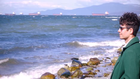 man sitting on beach on a sunny day 4k