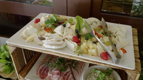 A-rustic-table-made-from-a-wooden-crate,-on-which-there-are-cheeses-and-cold-cuts