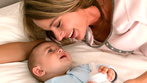 bebé siendo alimentado con botella con la madre en la cama