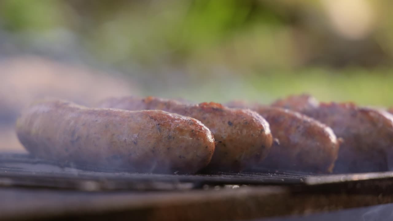 deliciosas salchichas jugosas, cocinadas en la parrilla con un fuego.