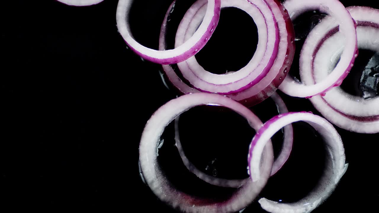 Onion rings roll on the water with a splash.