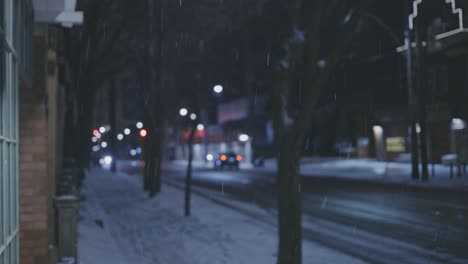 Schneefall-In-Der-Nacht-Mit-Bokeh-Fahrzeugen,-Die-Im-Winter-Auf-Der-Straße-Im-Hintergrund-Unterwegs-Sind