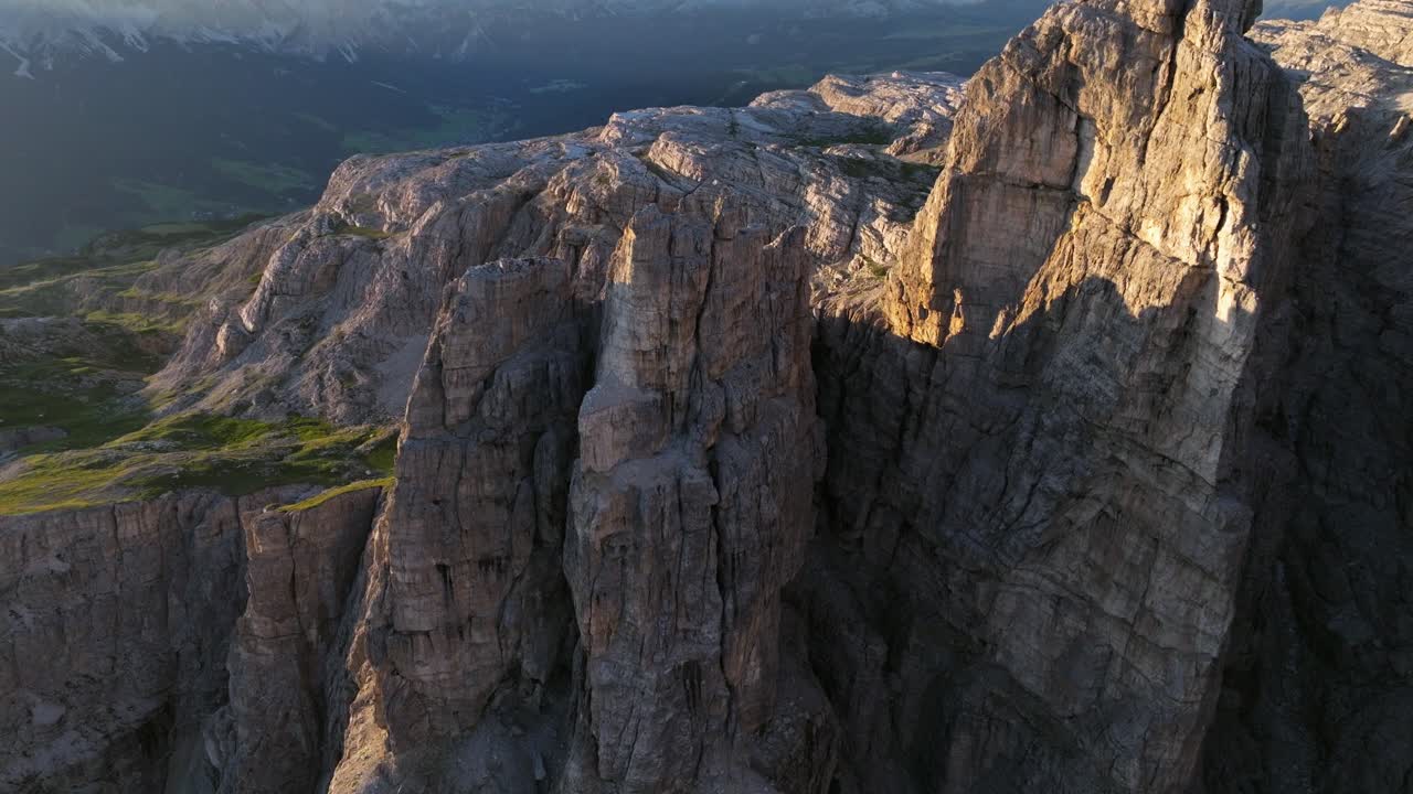Aerial view of the Dolomites' jagged peaks, illuminated by the soft morning glow shortly after sunrise