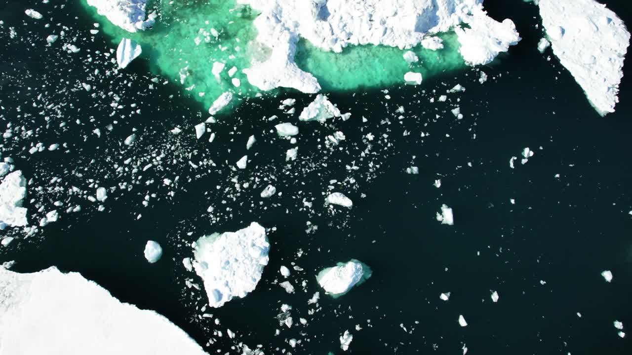 Dark deep ocean and floating icebergs, aerial drone view