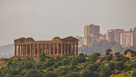 ancient temple of segesta and modern city in background, distance view