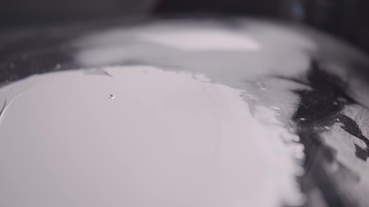 especialista en reparación de carrocerías de automóviles aplica cuidadosamente la masilla a la carrocería del automóvil de cerca