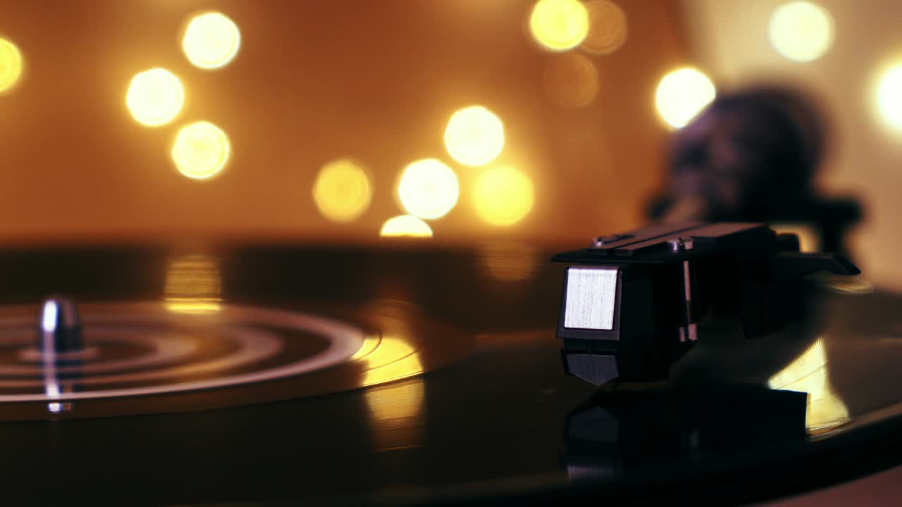 턴테이블 비닐 레코드 플레이어: 초점에서 디포커스: 가운 배경에서 그라모폰과 토크 플레이트 클로즈업; 밝은 보케를 배경으로 바늘 클로즈업을 가진 스타일러