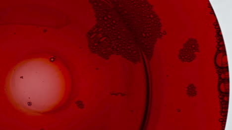 sizzling foam red liquor surface closeup. bubbled wine texture moving slowly