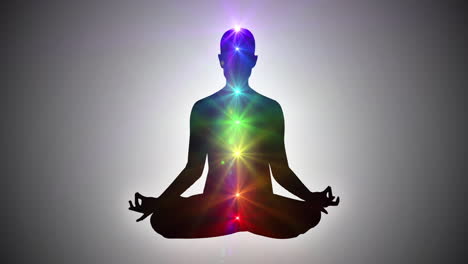 silhouette of a person sitting in lotus yoga pose achieving nirvana or enlightenment | seven chakras