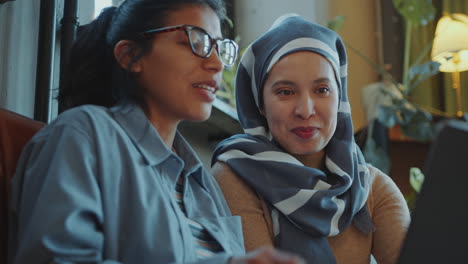 hispanic businesswoman discussing work with muslim colleague in office