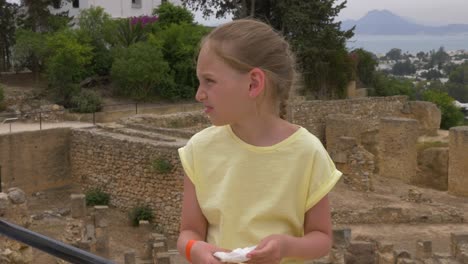 girl teenager wiping hands with napkins while excursion in carthage in tunisia