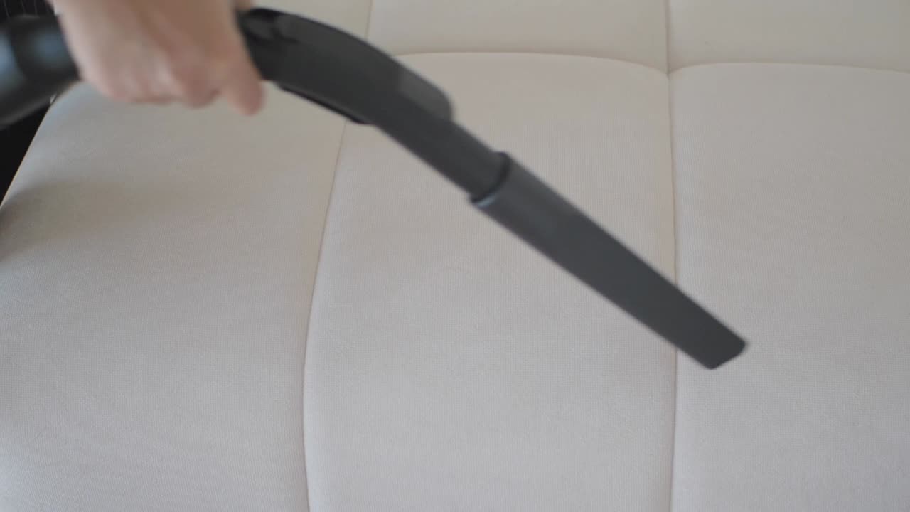 Vysávání bílé čalouněné židle nebo pohovky