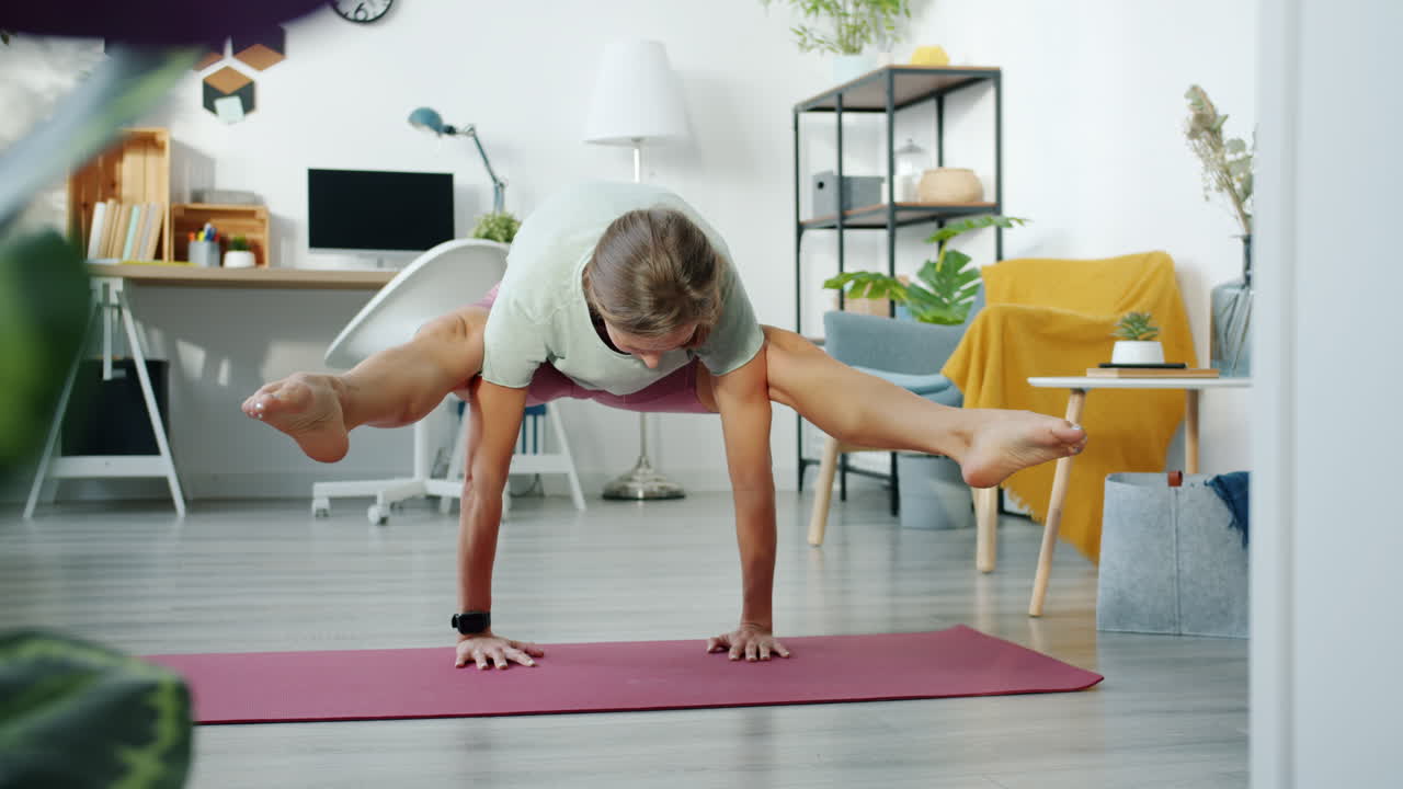 Woman practicing Eka Pada Koundinyasana yoga pose at home