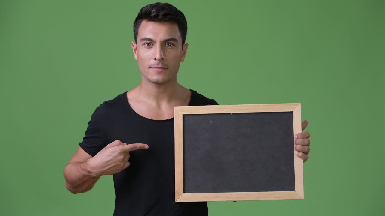 초록색 배경에 젊은 잘생긴 히스패닉 남자