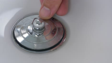 close-up slow motion shot of plug hole hands being filled up with bubbles water sink basin bowl bathroom kitchen personal hygiene washing 4k