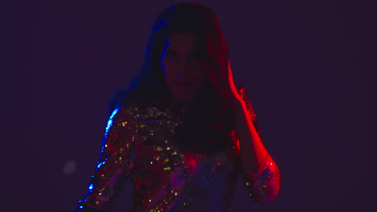 primer plano de una mujer en un bar nocturno o discoteca bailando y divirtiéndose mirando a la cámara 2