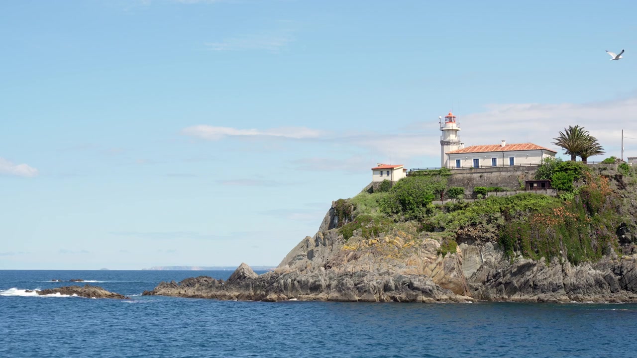 Faro su una scogliera rocciosa sopra l'oceano a Cudillero, Spagna