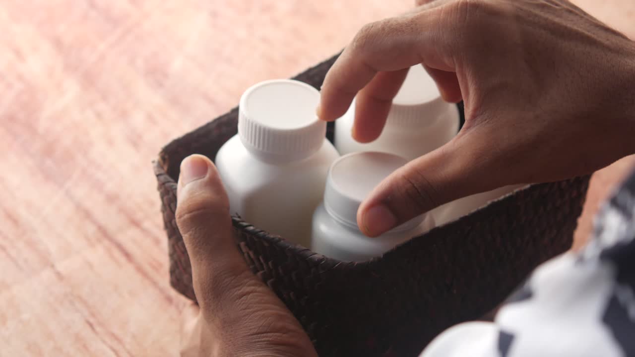 병 을 바구니 에 넣고 있는 사람