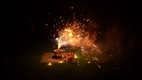 fireworks in plant pot in yard smoke with bright clors and cracking sparks