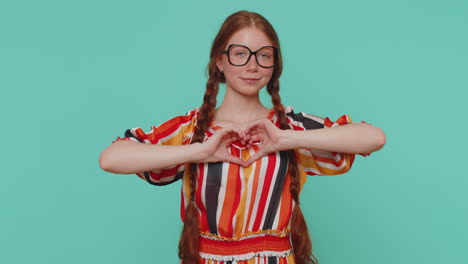 Smiling-ginger-girl-makes-heart-gesture-demonstrates-love-sign-expresses-good-feelings-and-sympathy