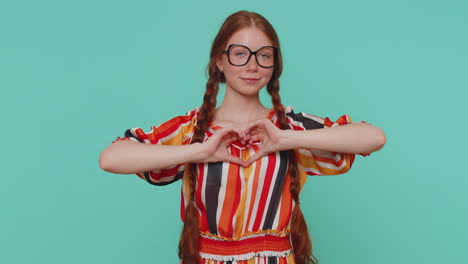 la chica roja sonriente hace un gesto de corazón demuestra un signo de amor expresa buenos sentimientos y simpatía