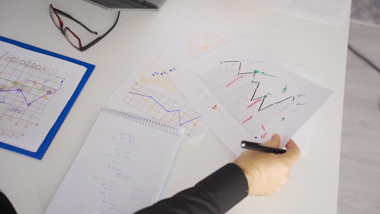 Two businessmen calculate financial expenses by looking at graphs and charts.