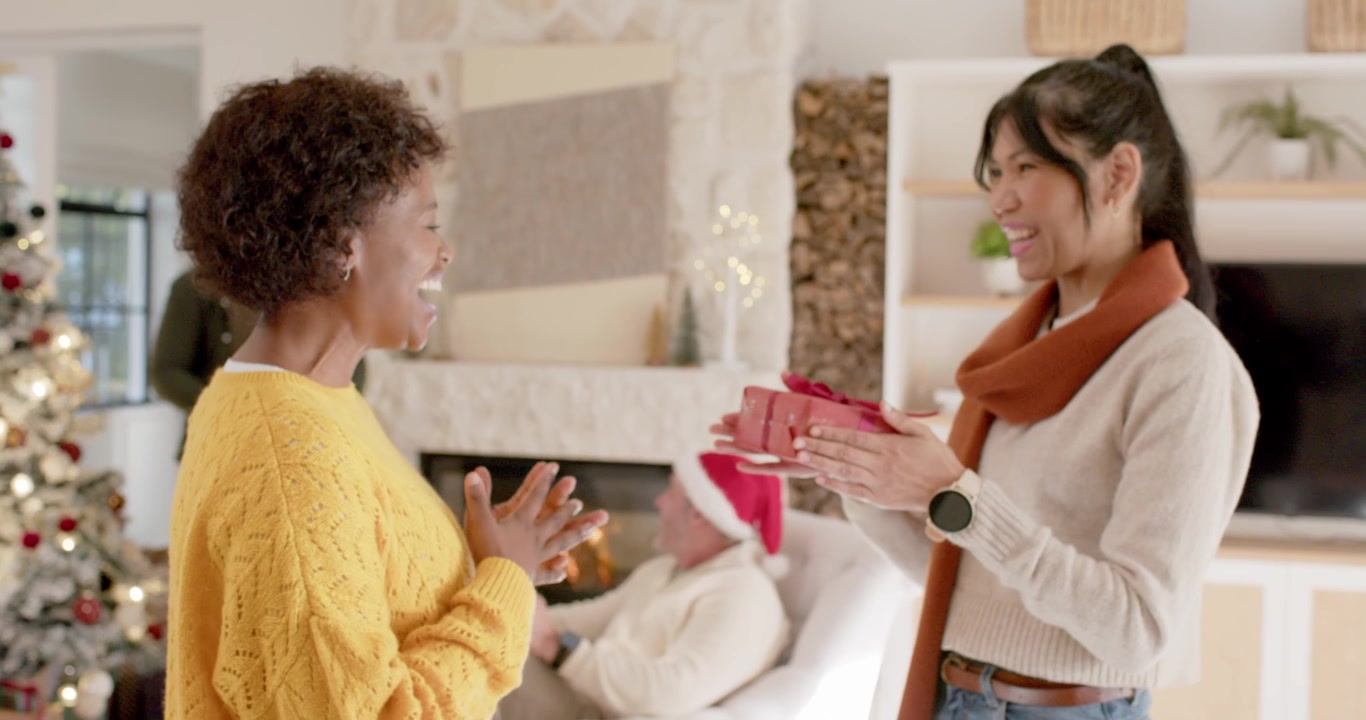 Giovane donna che dona un regalo di Natale alla sua amica