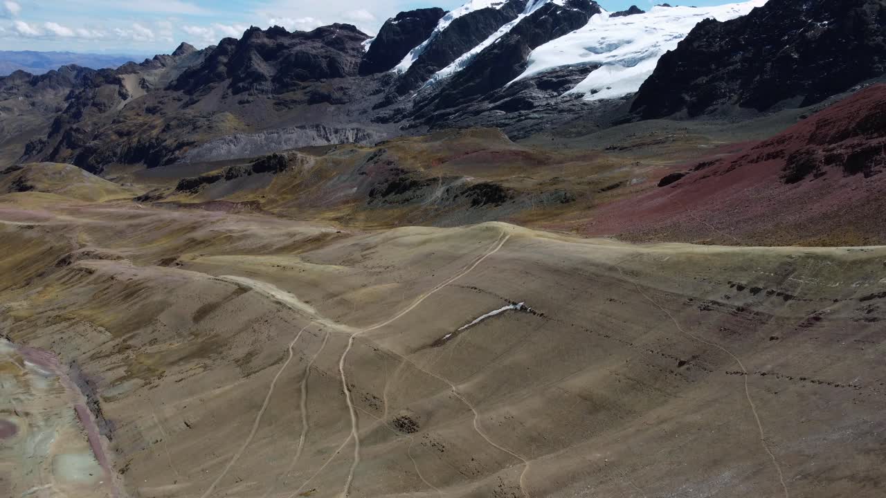 Expansive aerial of Rainbow Mountain, Peru, featuring vibrant mineral rich slopes