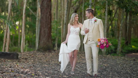 slow motion caucasian bride and groom walking talking in nature green forest on wedding day, 4k slow motion