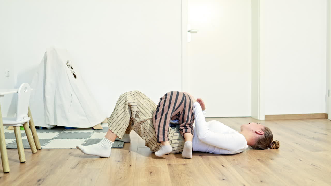Mom playing with her little son at home. Mom and son playing together in a bright living room. Happy mom and child. Loving atmosphere between mom and child
