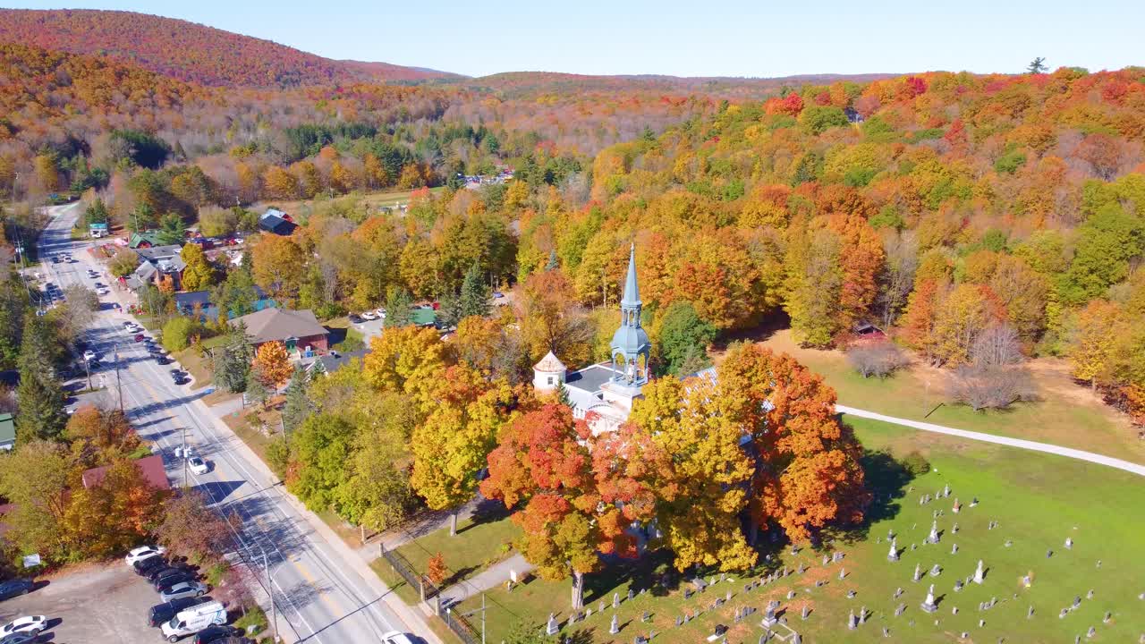 Small town and church steeple surrounded by beautiful fall covers and rolling hills