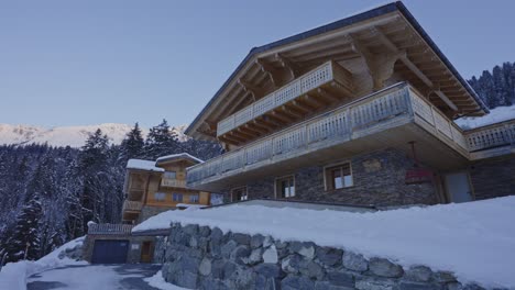 panning from a beautiful snow covered valley to a luxurious chalet in the swiss countryside